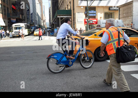 Uomo in bicicletta sul citi noleggio bici noleggio bici schema uomo a camminare e taxi midtown Manhattan New York City USA Foto Stock