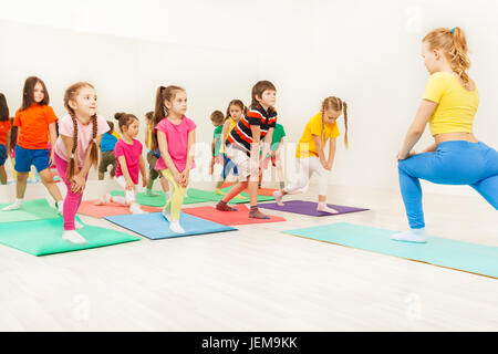 I bambini facendo esercizi ginnici in classe di fitness Foto Stock