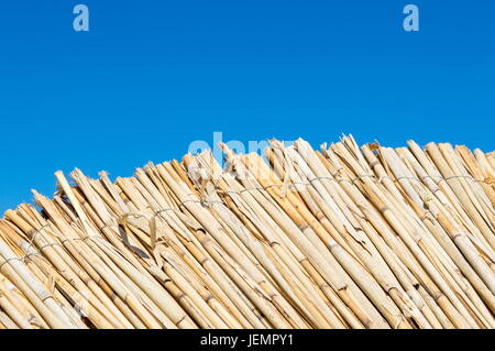 Ombrello di paglia contro il cielo blu in spiaggia Foto Stock