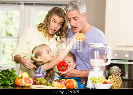 La famiglia felice preparazione frullato sano Foto Stock