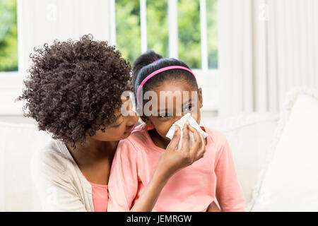 Madre aiutare mia figlia soffia il naso Foto Stock