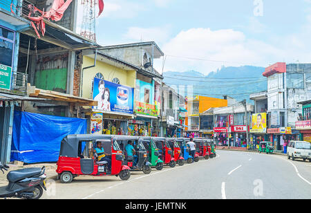 PUSSELAWA, SRI LANKA - Novembre 29, 2016: la strada principale della cittadina, situato nelle montagne di piantagioni di tè regione con parcheggiato tuk tuks e v Foto Stock