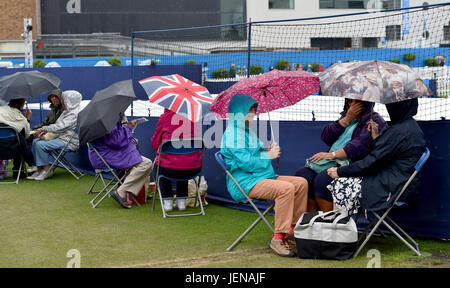 Eastbourne Sussex, Regno Unito. Il 27 giugno, 2017. Spettatori riparo sotto gli ombrelli da pioggia smette di giocare al Aegon International Eastbourne Tennis Tournament come una miscela di docce e temporali si è diffusa in tutto il sud est della Gran Bretagna oggi Credito: Simon Dack/Alamy Live News Foto Stock
