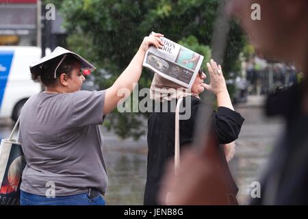 South Kensington, Londra, Regno Unito. 27 GIU, 2017. Docce a pioggia attraverso, Regno Unito. Il 27 giugno, 2017. La figura mostra le persone che coprono fino evitando i pesanti rovesci di pioggia come weathwer si rompe dopo le alte temperature e di recente il bel tempo nella capitale Londra., Inghilterra UK Credit: Clickpics/Alamy Live News Foto Stock