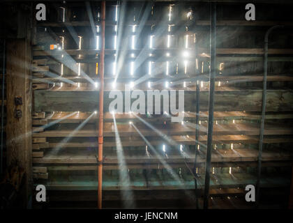 La luce del sole che splende attraverso le travi di legno in mansarda Foto Stock