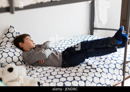 Ragazzo disteso sul suo letto fantasticando Foto Stock