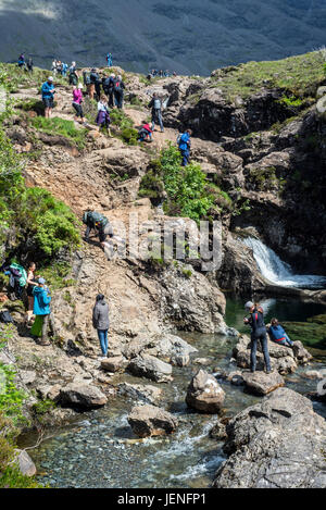 Un folto gruppo di turisti che visitano la Fata Piscine, successione di cascate in Glen fragili sull'Isola di Skye, Highlands scozzesi, Scotland, Regno Unito Foto Stock