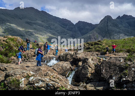 Un folto gruppo di turisti che visitano la Fata Piscine, successione di cascate in Glen fragili sull'Isola di Skye, Highlands scozzesi, Scotland, Regno Unito Foto Stock