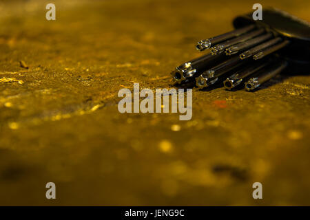 Set di Torx antimanomissione con tasti in un supporto sulla parte superiore di un vecchio banco in legno. Foto Stock