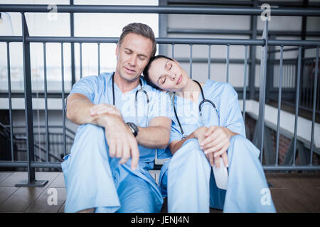 Stanco team medico di addormentarsi sul pavimento Foto Stock