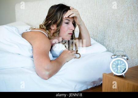 La donna nel suo letto cercando sottolineato Foto Stock