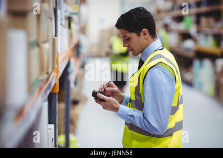 Lavoratore di magazzino tramite scanner a mano Foto Stock