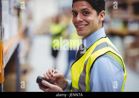 Lavoratore di magazzino tramite scanner a mano Foto Stock