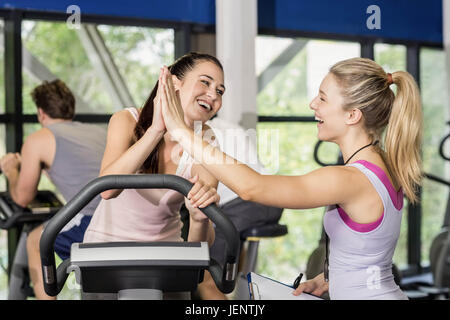 Trainer donna e sportive di alta fiving Foto Stock