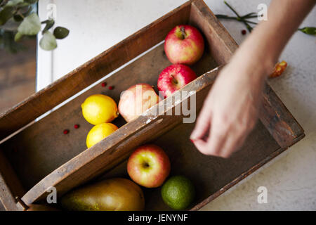 Frutta in scatola di legno, mano sul primo piano Foto Stock
