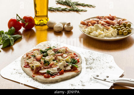 Un sormontato Pizza su una buccia pronto per il forno Foto Stock