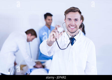 Medico che mostra uno stetoscopio verso la telecamera Foto Stock