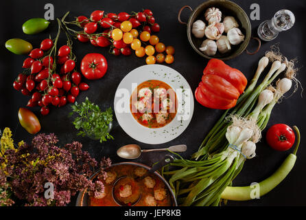 Polpette di zuppa, un tipico piatto della cucina rumena, chiamato ciorba de perisoare e verdure utilizzate per la preparazione. Foto Stock