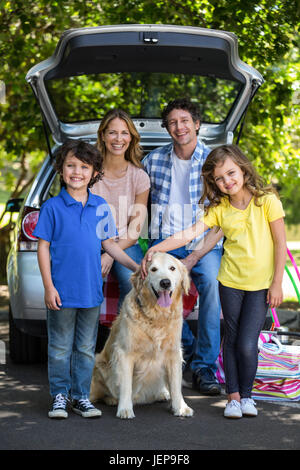 Famiglia sorridente nella parte anteriore di una macchina Foto Stock