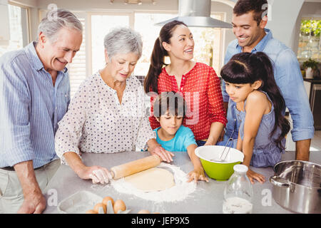 Donna senior di preparare il cibo con la famiglia Foto Stock
