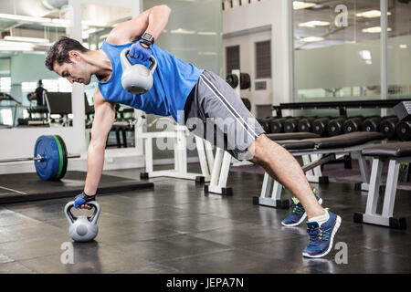 Uomo muscolare facendo esercizi con kettlebells Foto Stock