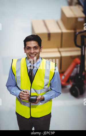 Lavoratore di magazzino tramite scanner a mano Foto Stock