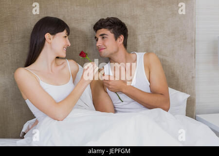 L'uomo che offre una rosa rossa per donna Foto Stock