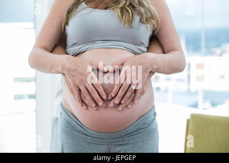 Uomo con la gravidanza womans stomaco Foto Stock