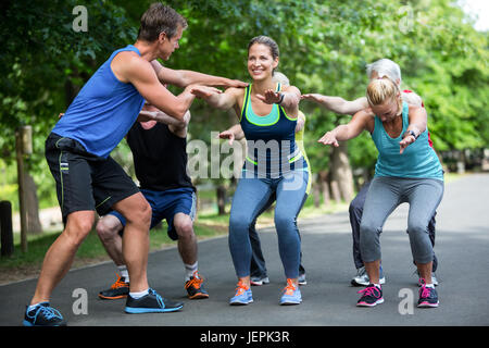 Lezione di fitness facendo sequenza squat Foto Stock