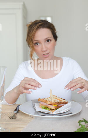 La donna è di andare a fare colazione con un sandwich Foto Stock