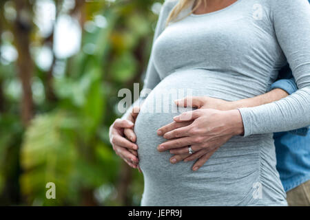 Uomo con la gravidanza womans stomaco Foto Stock