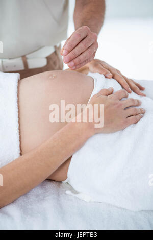 Donna incinta in una terapia di agopuntura Foto Stock