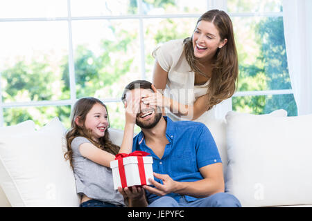 L'uomo sorpreso con il regalo in divano Foto Stock