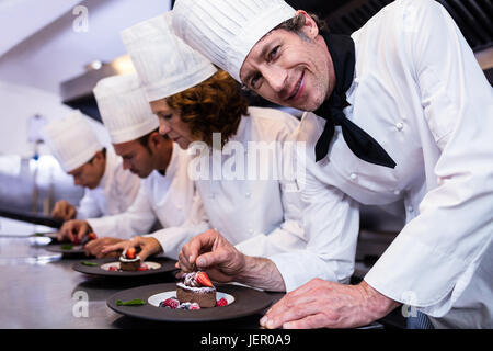 Il team degli chef la finitura piatti da dessert Foto Stock