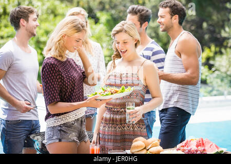 Amici preparando per esterni barbecue party Foto Stock