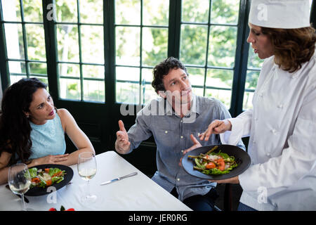 Giovane lamentando il cibo di chef Foto Stock