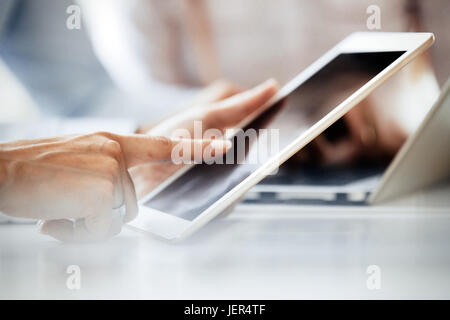 Chiudere l immagine dell uomo d affari utilizzando compressa sulla scrivania in ufficio Foto Stock