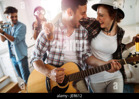 Allegro giovani amici di partito e insieme a suonare strumenti Foto Stock