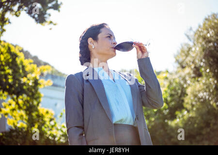 Piuttosto imprenditrice avente un bicchiere di vino Foto Stock