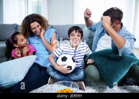 Famiglia guardare la partita insieme sul televisore Foto Stock