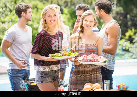 Amici preparando per esterni barbecue party Foto Stock