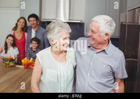 Nonni felici con la famiglia in cucina Foto Stock