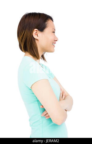 Giovane donna in piedi con le braccia incrociate Foto Stock