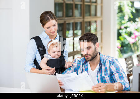 L uomo e la donna con il bambino alla lettura di documenti Foto Stock