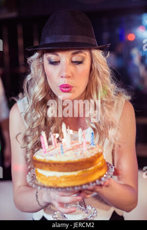 Donna soffiando fuori candele Foto Stock