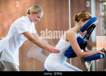 Donna ricevere massaggi in poltrona di massaggio Foto Stock