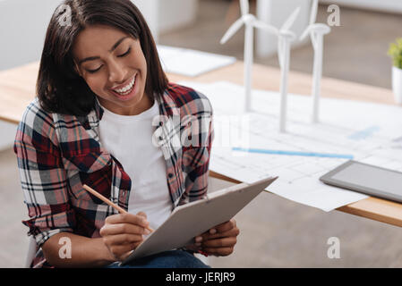 Piacevole donna allegra osservando le sue osservazioni Foto Stock