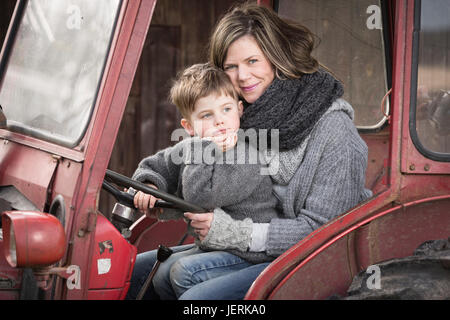 Donna con Figlio seduto nel trattore Foto Stock