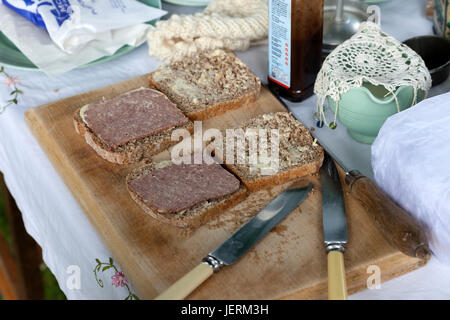 " Corned beef " i panini su una breadboard con posate e vasellame da anni quaranta. Foto Stock