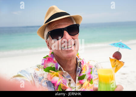 Felice l'uomo senior con un cocktail di benvenuto Foto Stock